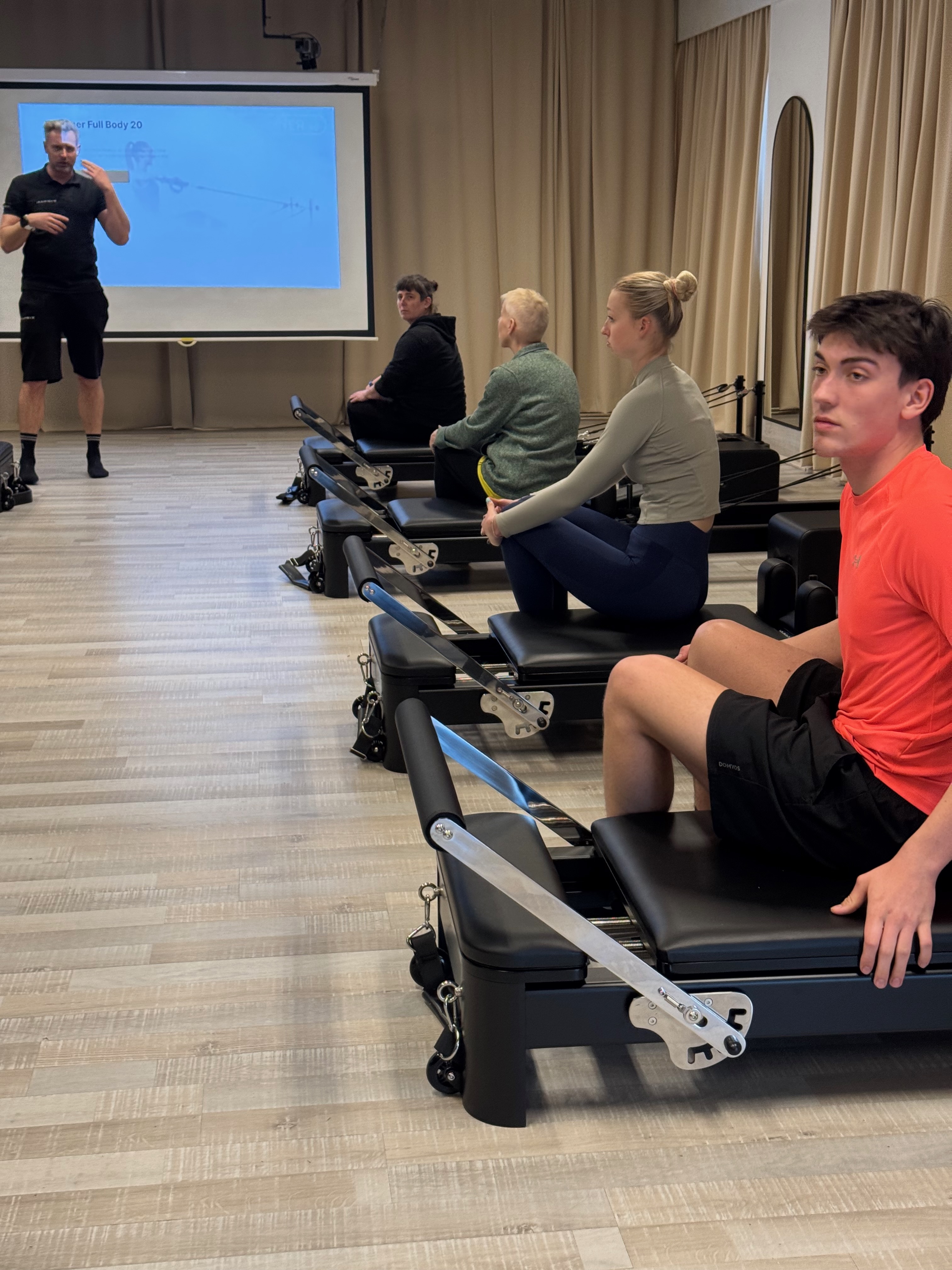 Coach legt oefening uit op de reformer